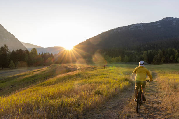 Mountain biker rides through meadow at sunrise