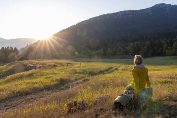Hiker watches sunrise over mountains