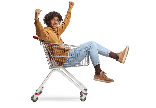 Happy african american young man sitting inside a shopping cart isolated on white background