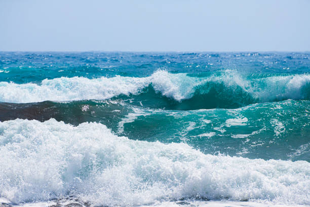 Exploding blue wave breaking on exposed rock in the ocean with warm morning light. Shot off the south west coast of Australia.