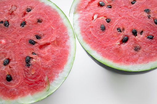 Two halves of watermelon on a white background. Summer berry - red watermelon. Ripe waterbeuse with seeds.