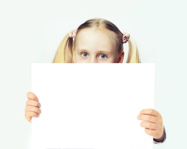 istock Attractive young girl with white empty blank banner board in her hands 1650751317