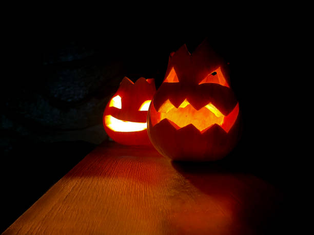 istock Two halloween pumpkins with faces and candles within 1650751831