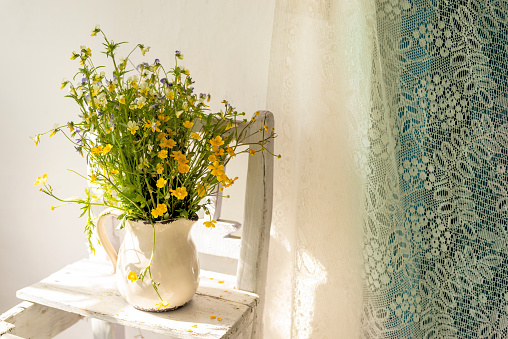 A lovely bouquet of wild flowers in an earthenware jug . Vintage village photo. bright room. provence and summer mood