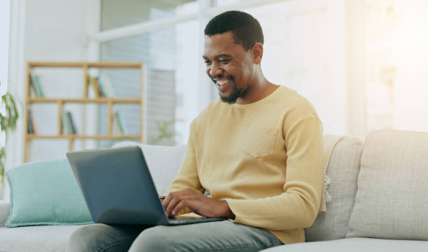 istock Typing, laptop keyboard and black man on sofa working on online report, research and internet blogging. Communication, remote work and happy male type on computer for website, writing email and busy 1650766762
