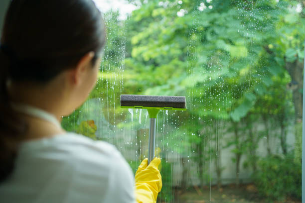 istock Female housekeeper cleaning window. 1650766764