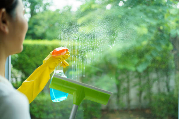 istock Female housekeeper cleaning window. 1650767294