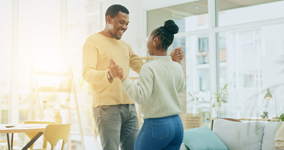 Black couple, dancing together and hug in home with care, happy and love with bonding. Man, woman and dance with support, happiness and celebration with solidarity in house with trust in partnership