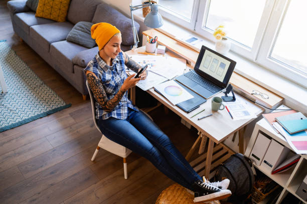 istock Young woman using phone while working at her home office 1650785039