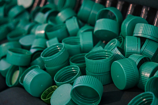 Close-up shot of green plastic water bottle cap piles together