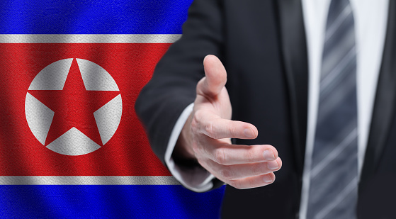 North Korea politics concept. Hand on flag of North Korea background.