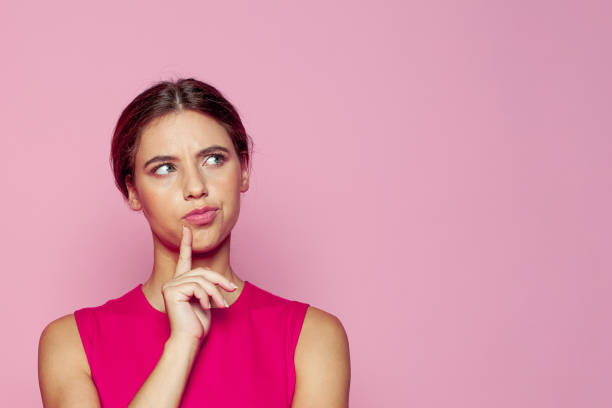 istock Attractive young woman thinking on pink background. Idea and brainstorming concept 1650800904