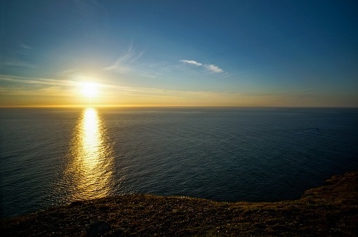 A beautiful orange sunset over an ocean bay. Thee sun reflects in the water. Picture from the Swedish west coast