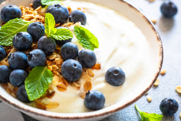 istock Greek Yogurt, granola and blueberry at light stone table. 1650826187