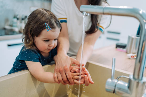 istock Mother teaching her daughter to wash her hands with soap. 1650829986