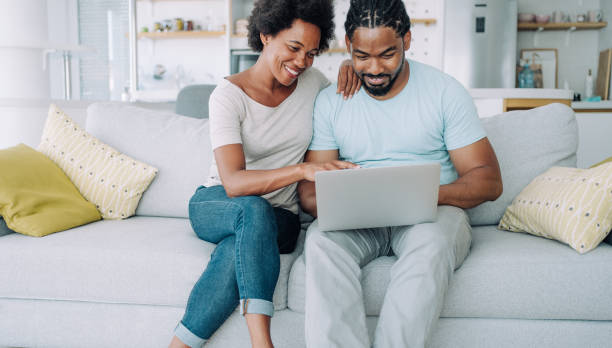 istock Couple using laptop on the sofa at home. 1650830507