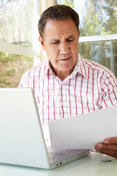 istock Senior Hispanic Man Working In Home Office 165084578