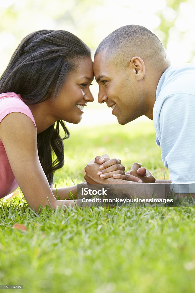 Portrait Of Romantic Young African American Couple In Park Portrait Of Romantic Young African American Couple Laying In Park Facing Each Other And Smiling 20-29 Years Stock Photo