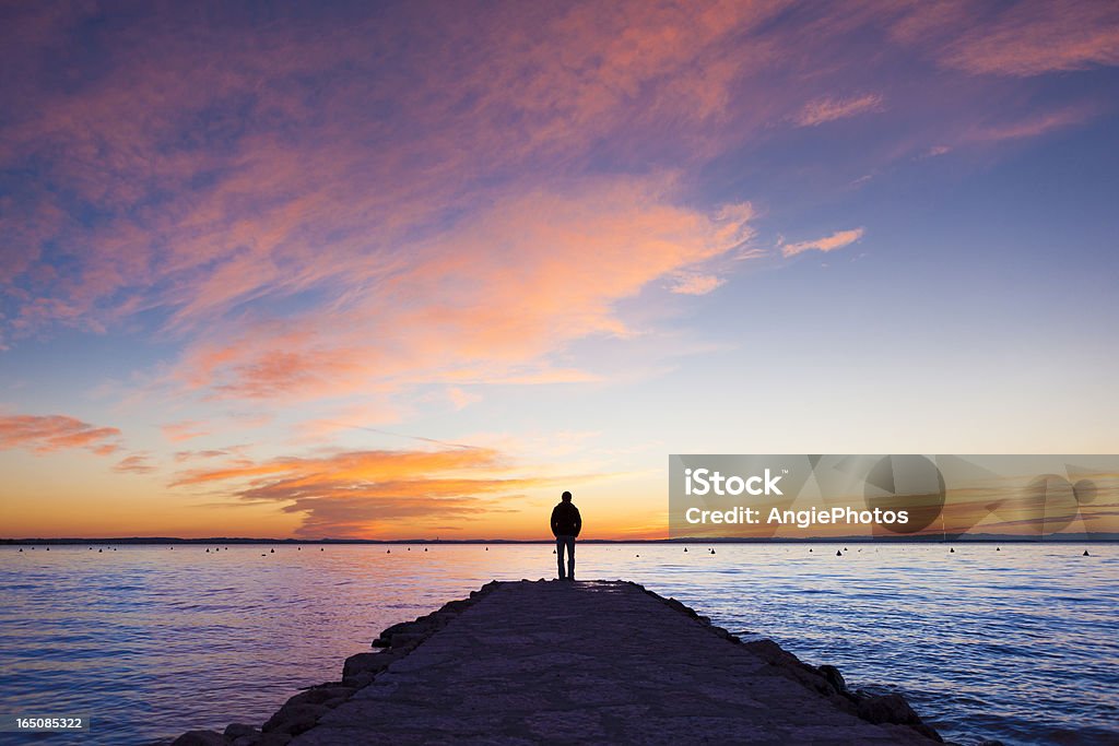 Man standing on jetty Sunset Stock Photo