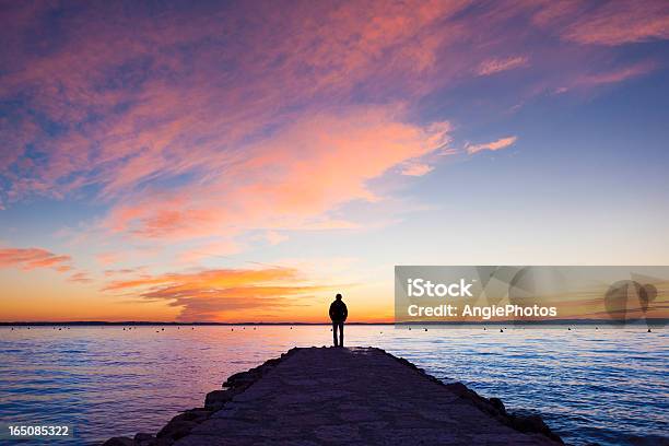 Man Standing On Jetty Stock Photo - Download Image Now - Sunset, Sea, People