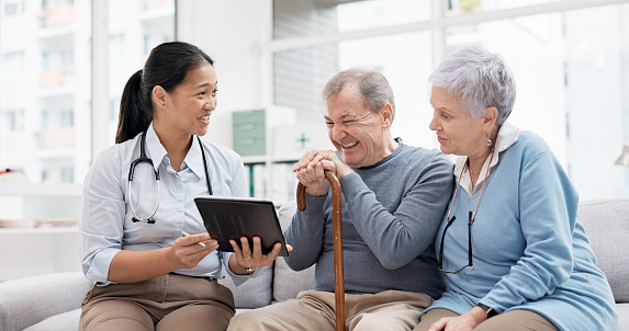 Healthcare, doctor tablet and senior couple with digital results in retirement home with caregiver support. Nursing, technology and online information with communication and elderly patient with talk