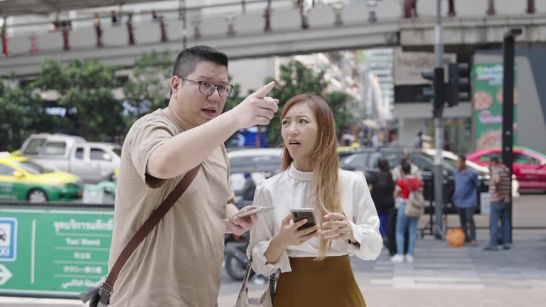 Overweight Asian Man and Lovely Woman Discussing  to Find the Place of Meeting Point