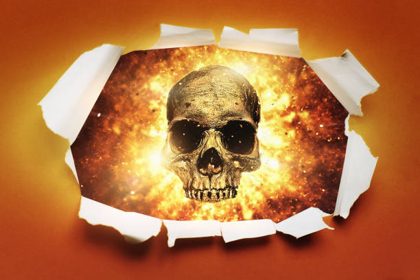 Exploding skull bursts through hole in paper with torn jagged edges Flaming skull bursts through a sheet of bright orange paper, with curled and ripped edges. burned corpse stock pictures, royalty-free photos & images