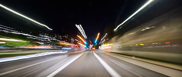 Light trails on road. High speed driving makes abstract light trails at dusk.