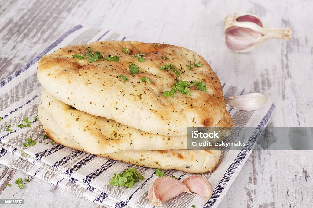 Bright naan background. Luxurious naan flatbread stack on white wooden textured background. Culinary asian bread eating concept. Naan Bread Stock Photo