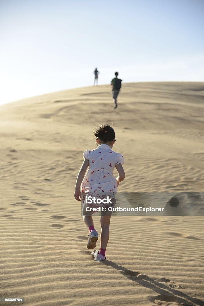 Młoda dziewczyna idąc przez desert po jej rodziny - Zbiór zdjęć royalty-free (Biały)