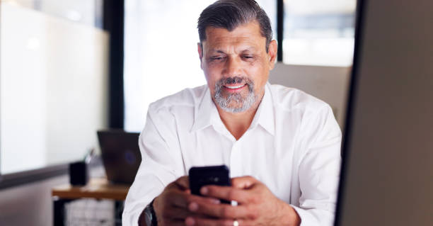 istock Business man, phone and office while typing for communication or chat about work while happy with network service, data and connection. Senior employee on social media for marketing and networking 1650858348