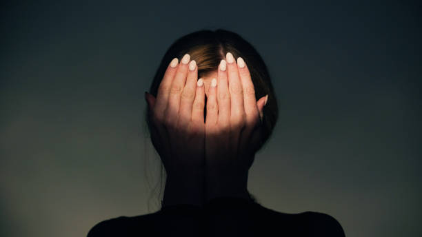 istock Woman covers her face with her hands in round light. Studio shot. 1650858883