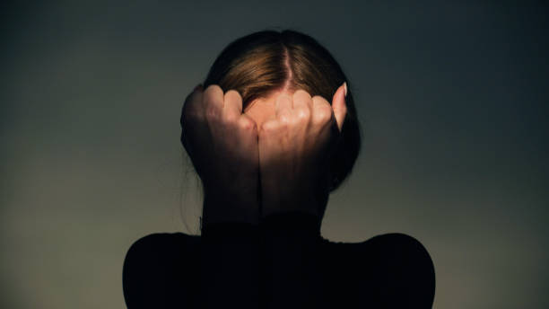 istock Woman covers her face with her hands in round light. Studio shot. 1650858887
