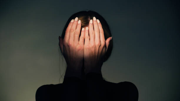 istock Woman covers her face with her hands in round light. Studio shot. 1650858901