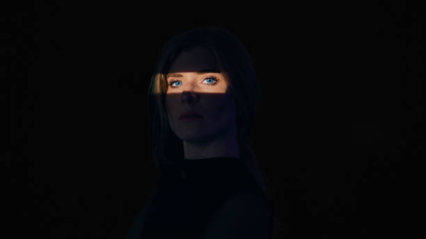 istock Woman in black.The light falls only on her eyes. 1650858970