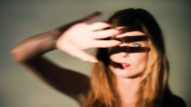istock A woman covers herself with her hand against the glaring light. 1650859026