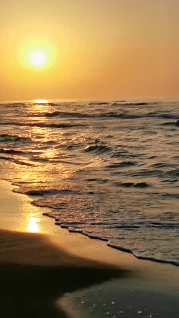 Vertical shot of sea waves at sunset