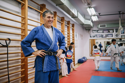 9 - 14 year old kids training judo with their sensei teacher at the dojo gym training ground.