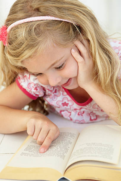 istock Young Girl Reading Book In Bedroom 165085960