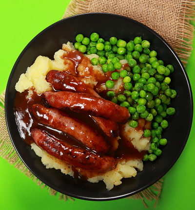 Bangers and mash with peas and gravy