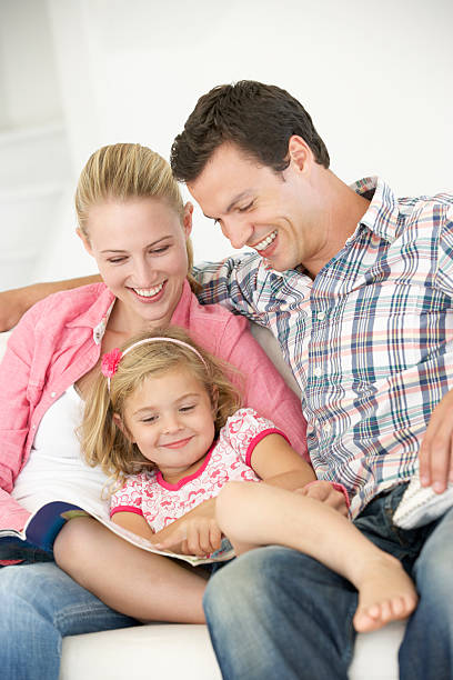 istock Parents Reading With Daughter At Home 165086038