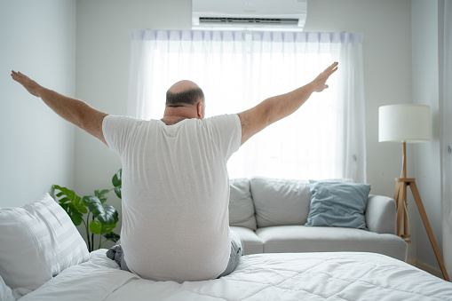 Cozy Morning Routine: Chubby Man Wakes Up and Stretches in Comfortable Home Ambience