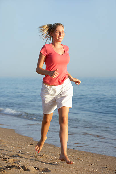 istock Woman Running Along Beach 165087473