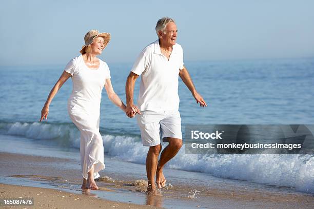 Coppia Senior Godendo Spiaggia Vacanza - Fotografie stock e altre immagini di Camminare - Camminare, Spiaggia, Darsi la mano