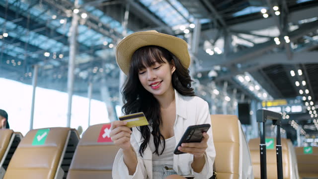 Asian woman using a smartphone while waiting for the departure in the airport