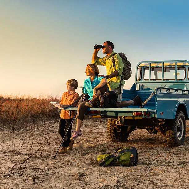 Photo of Backpacking family on vehicle at sunset