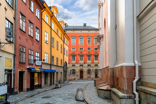 Narrow cobblestone alleys and streets of colorful medieval buildings with shops and cafes in the old town center of the island of Gamla Stan in Stockholm Sweden. The bustling, compact island of Gamla Stan is the city’s old town, with cobbled streets and colorful 17th- and 18th-century buildings. It’s home to the medieval Storkyrkan cathedral and the Royal Palace, the king’s official residence. Stylish bistros serve New Nordic cuisine, while night spots include old-school pubs and chic cocktail bars.