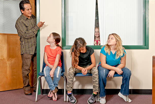 Three female students in trouble and awaiting the principal stock photo