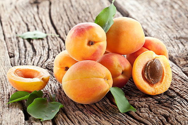 Apricots with leaves. Apricots with leaves on the old wooden table. apricot stock pictures, royalty-free photos & images