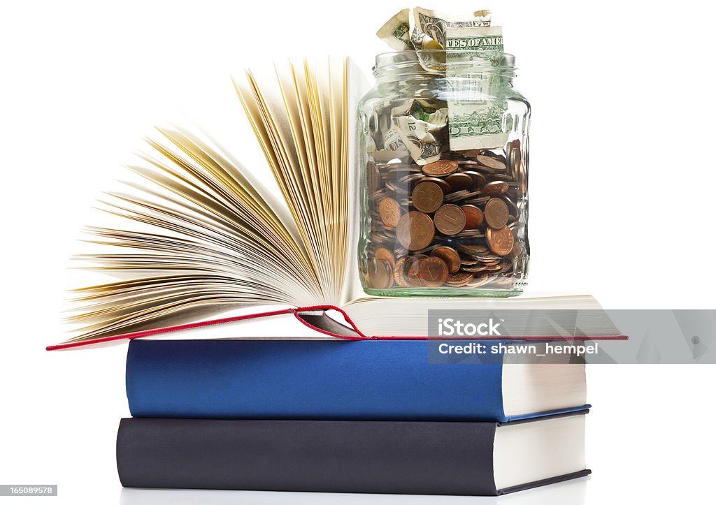 Education financing Books with penny jar filled with coins and banknotes - tuition or education financing concept Achievement Stock Photo